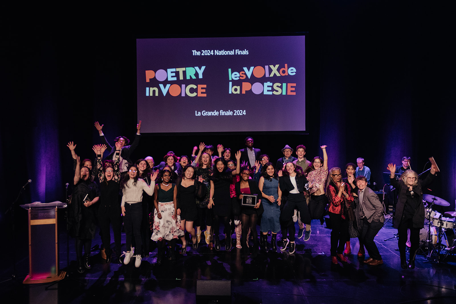 Photo de groupe des gagnants de la finale nationale, des FutureVersers, des animateurs et des juges sur la scène du Centre national des arts.