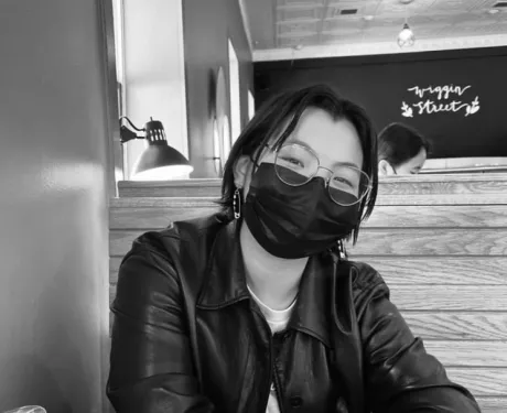 a young person with a mask on in a cafe