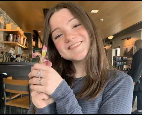 a young woman holding a flower