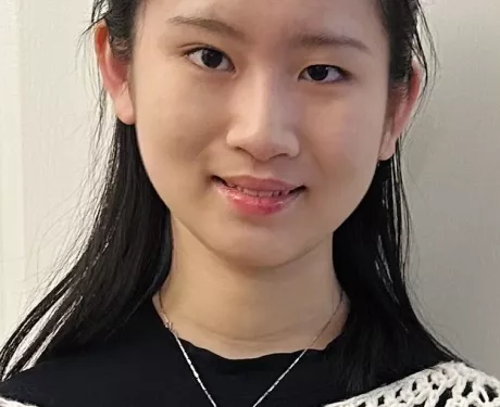A woman woman dressed in black and white looks at the camera