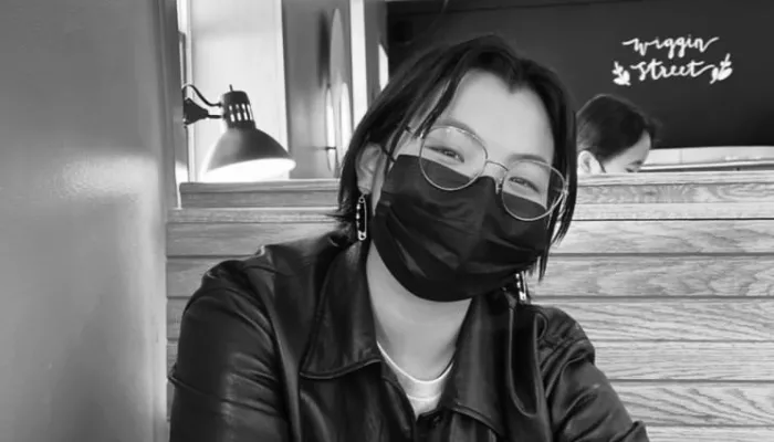a young person with a mask on in a cafe