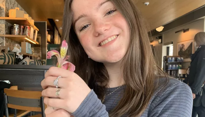 a young woman holding a flower
